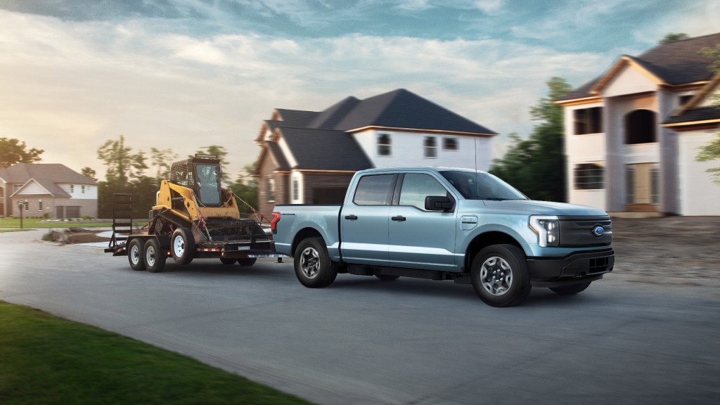 Ford F-150 Lightning hauling skid steer