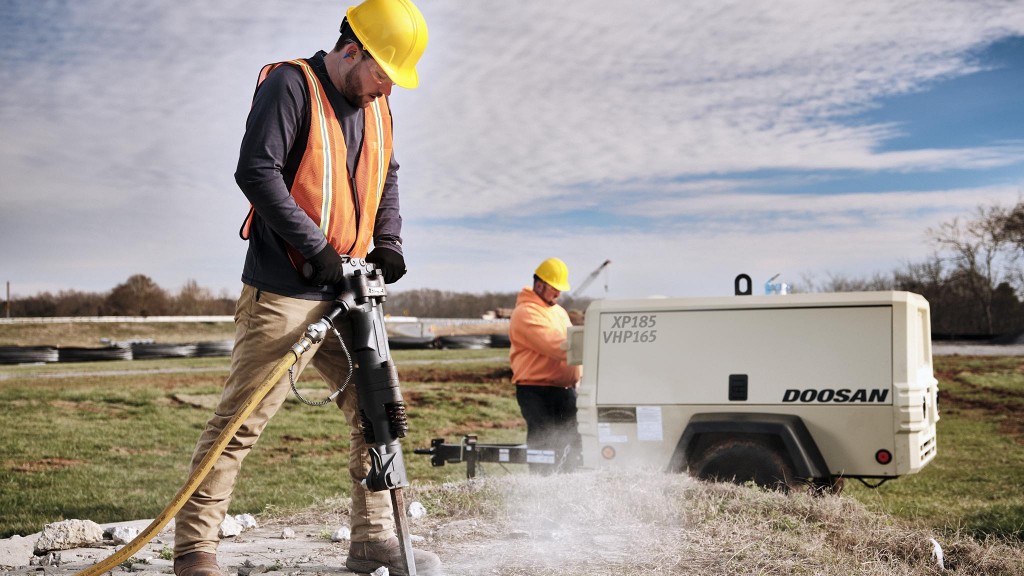 man using a doosan xp185 vhp165 air compressor for a breaker