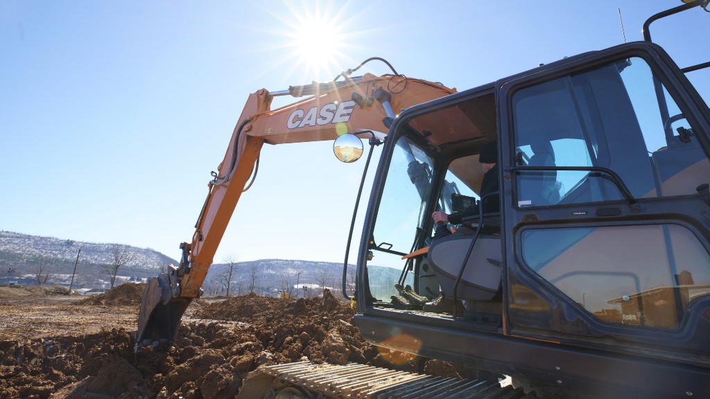 A Case excavator digs a hole on a job site