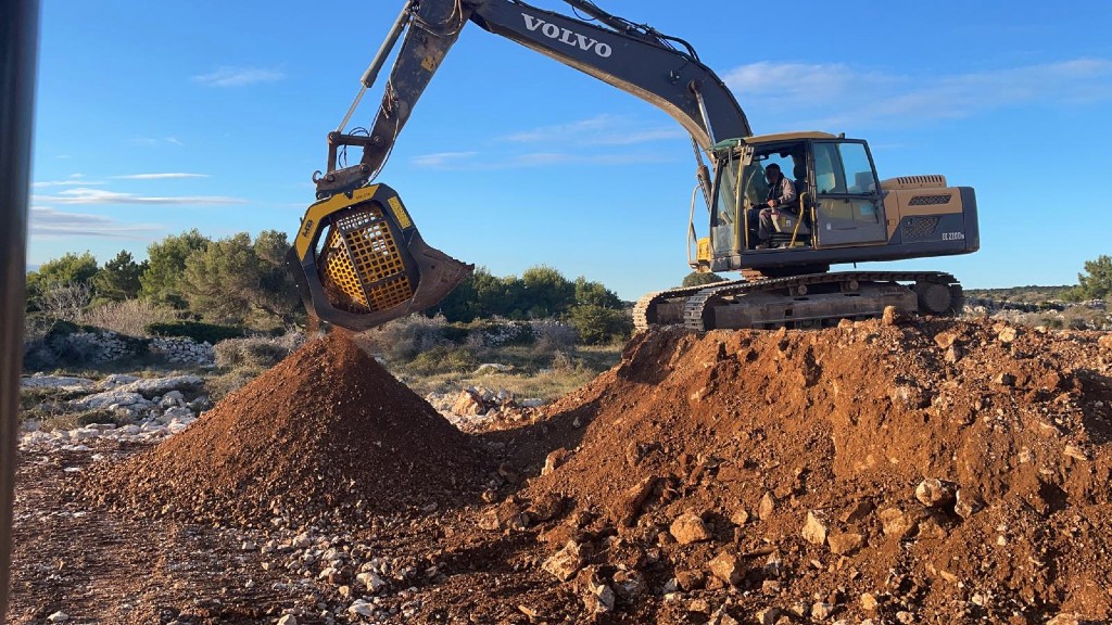 An excavator separating rock from soil