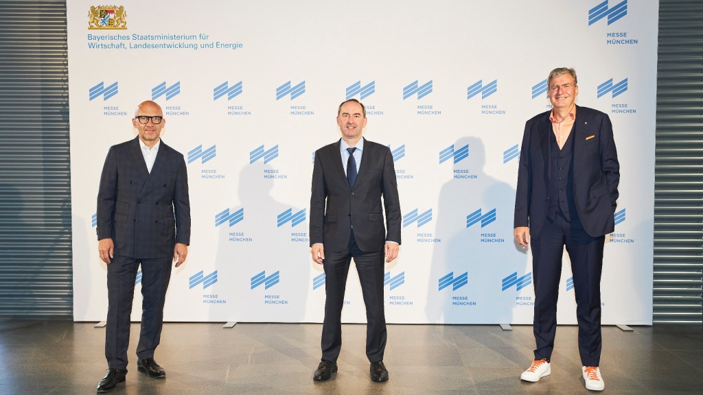 Three high-level employees in suits pose for a photo