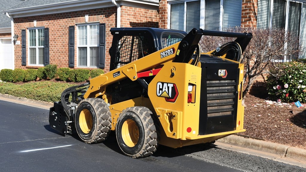 Cat skid steer with cold planer attachment on residential street