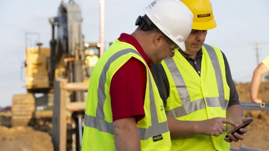 Two workers look at telematics on a tablet