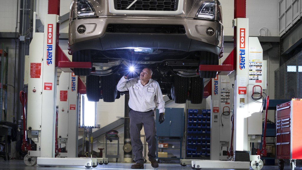 A mechanic works underneath a Volvo truck