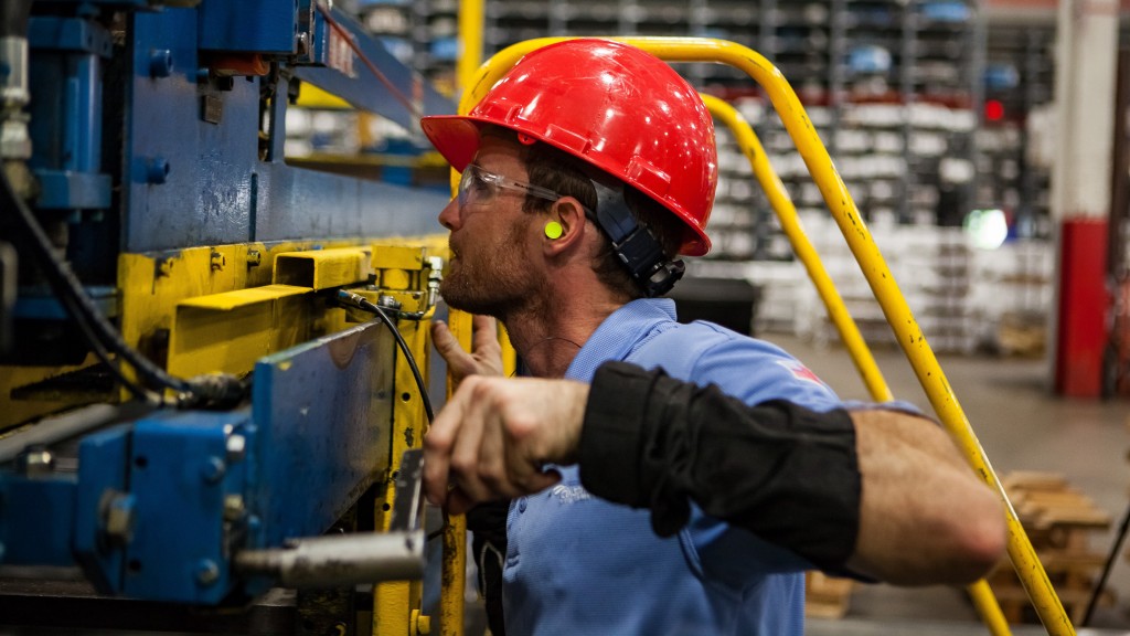 A worker operates a manufacturing machine.