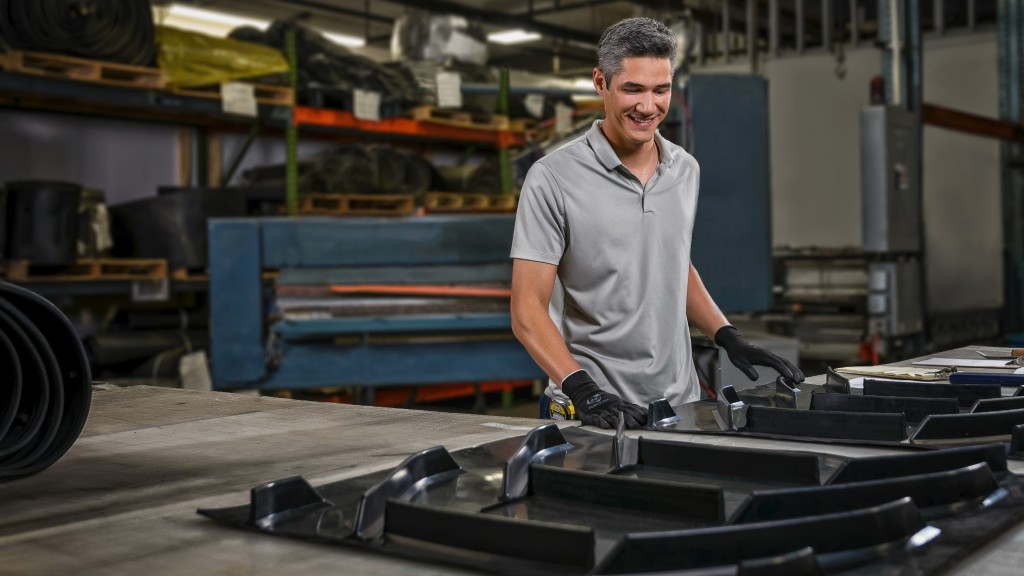 A worker connects pieces of cleated belt.