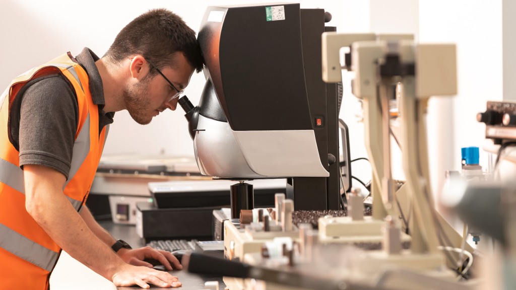 A worker looks into a microscope