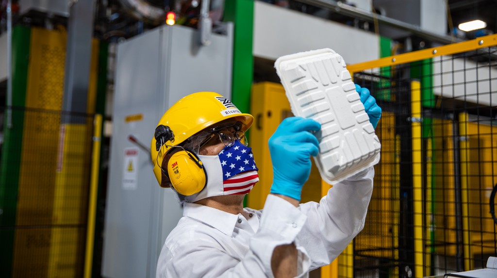 A Zume employee inspects a tray