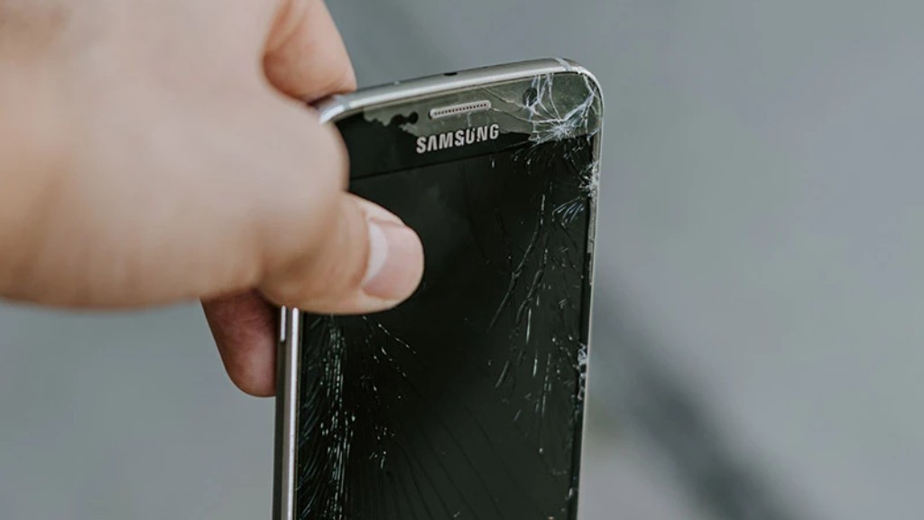 A hand holds a broken smartphone