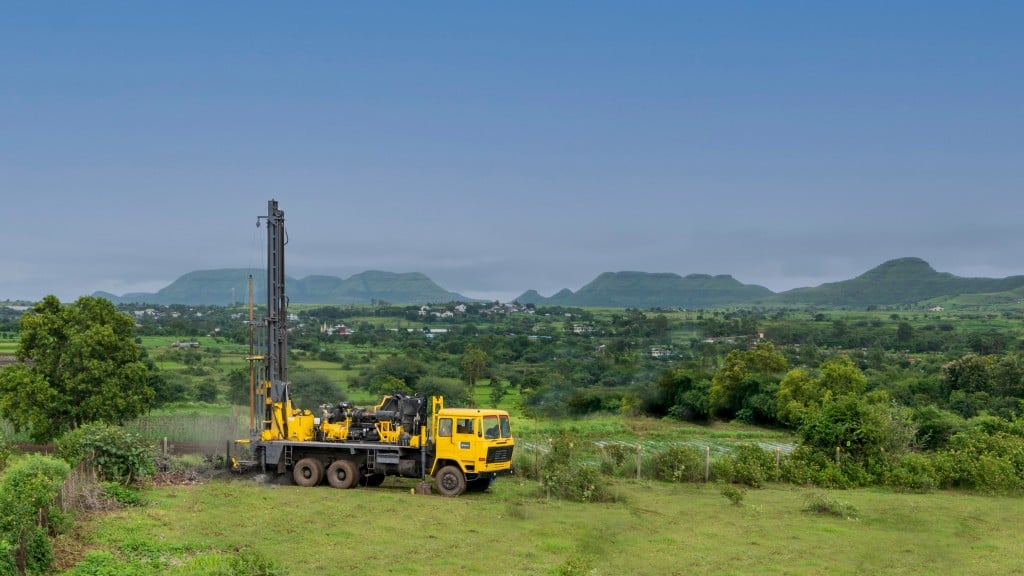 An Epiroc water well drill rig parked on rural hills