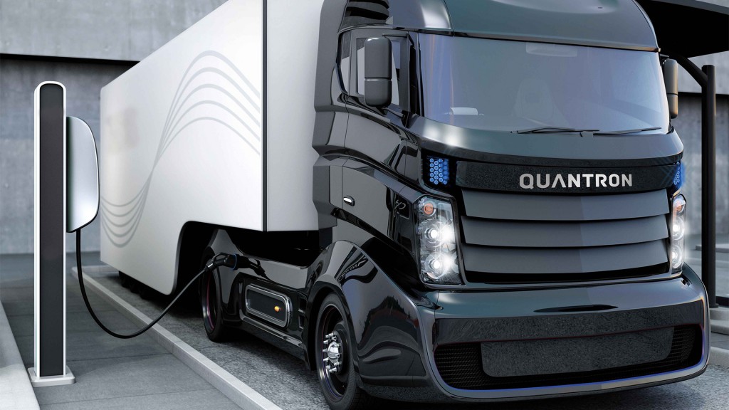 A Quantron truck charging at a charging station