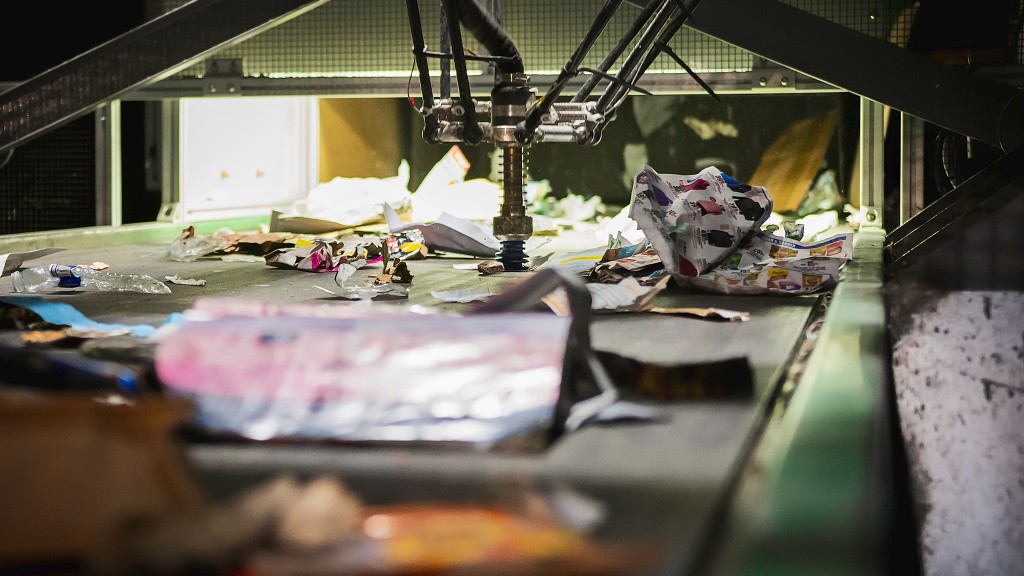 A robot sorts paper on a recycling conveyor