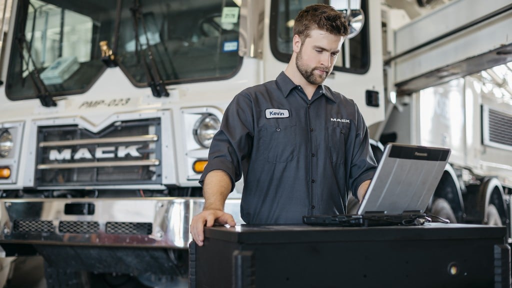 A technician maintains a Mack truck