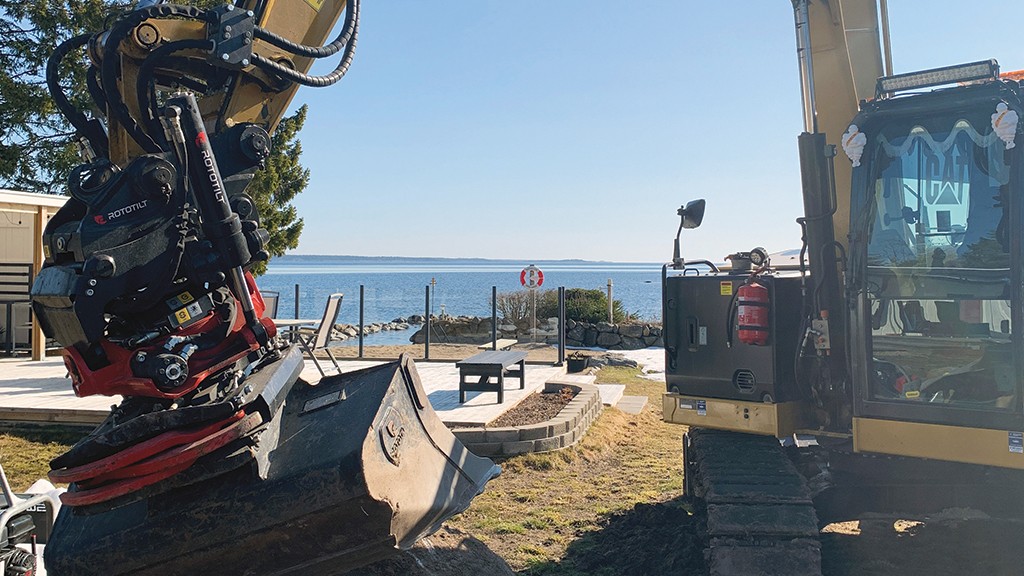 Tiltrotator mounted on excavator landscaping by the beach