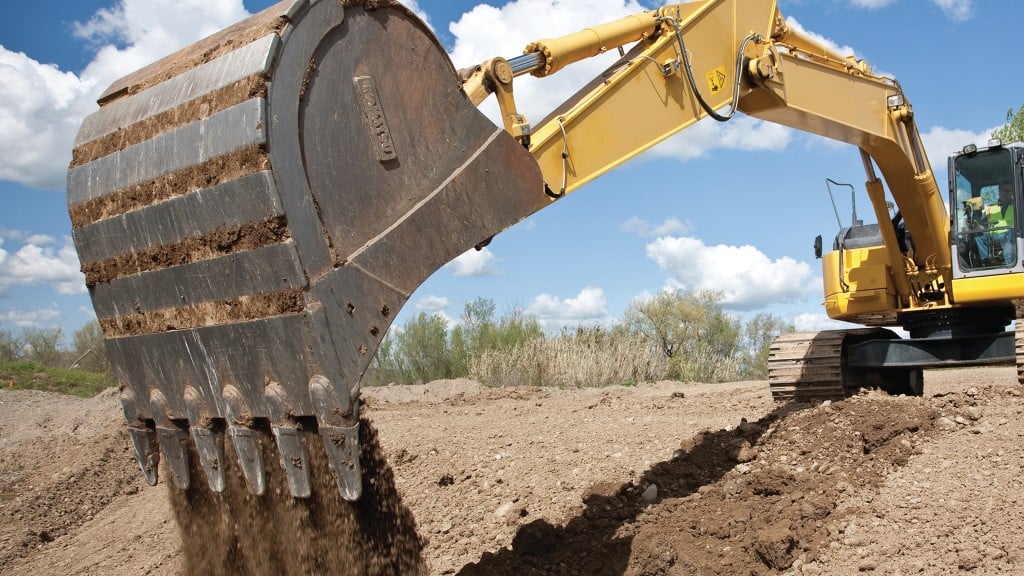 Excavator with bucket resting on trench side