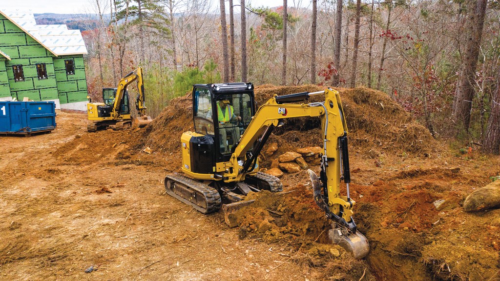 A Cat mini excavator digs on the job site