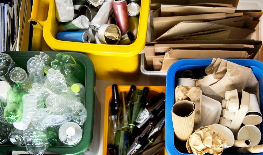 Various types of recyclable materials sorted into different coloured bins