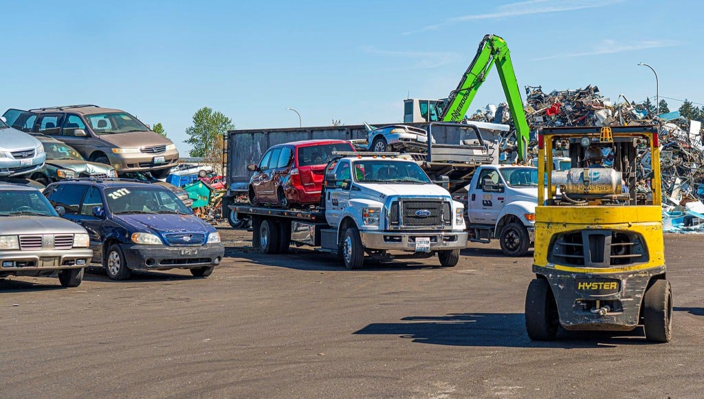 Autos in a scrapyard with loader