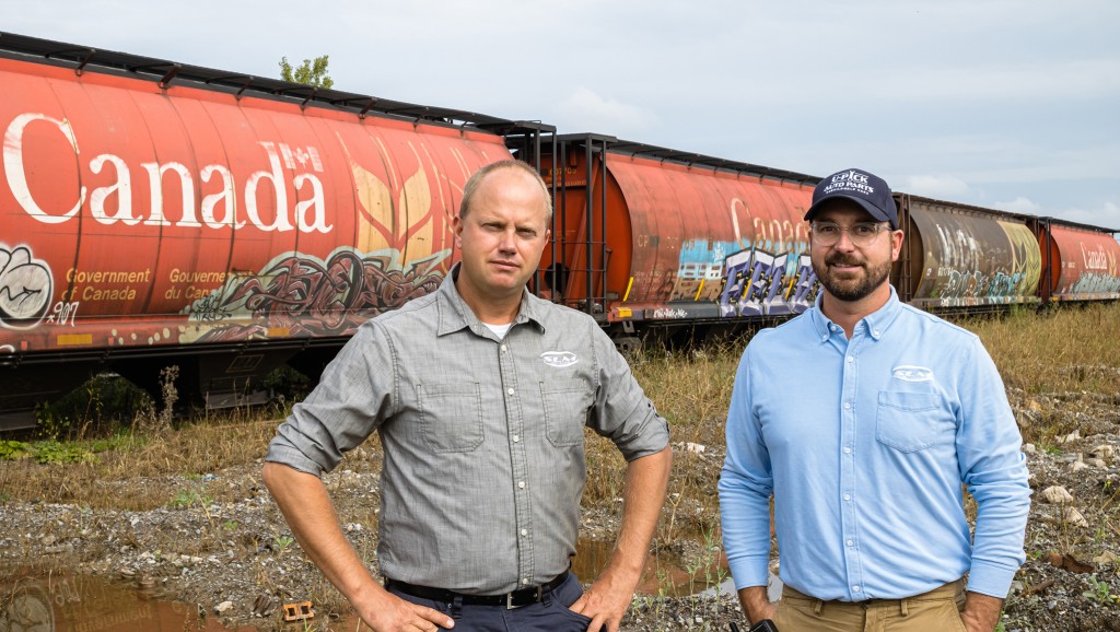 Stew Lehmann and Kyle Duncan in front of train cars