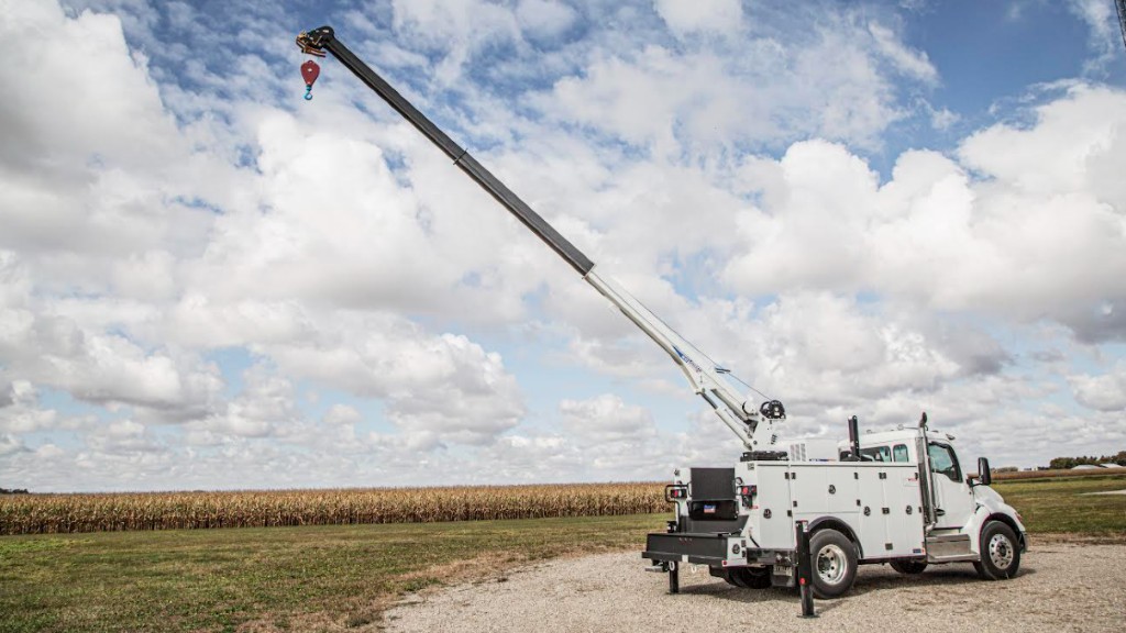 A service truck with telescoping crane outstretched