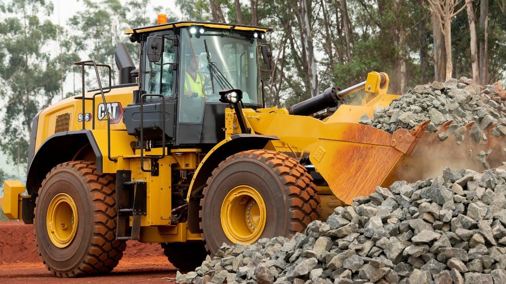 A Cat wheel loader loads rocks into its bucket on the job site