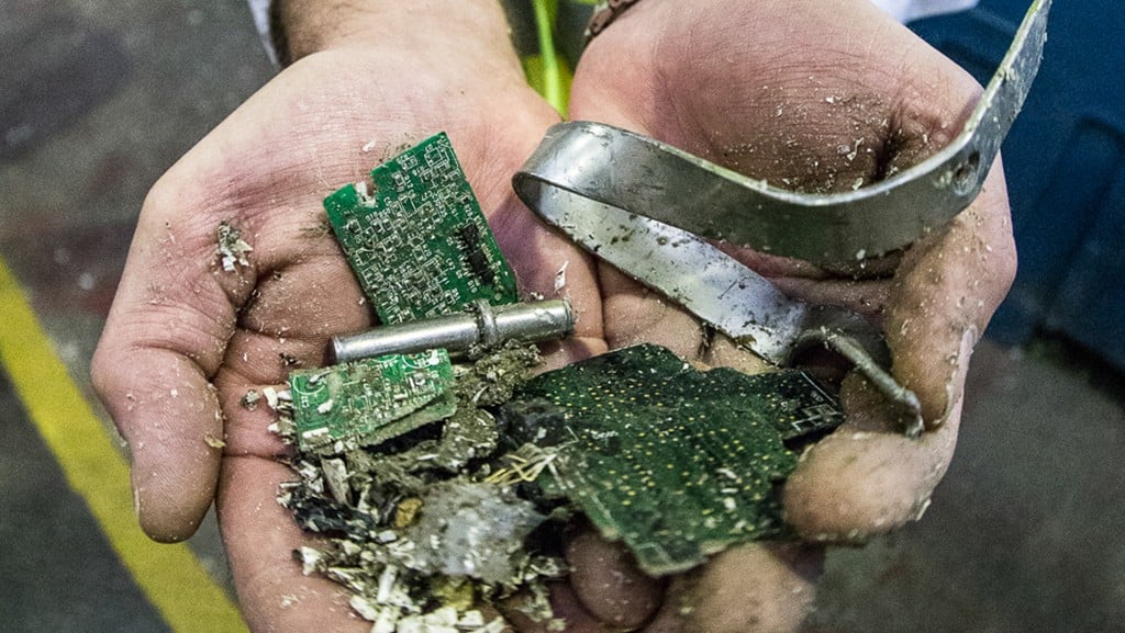 Separated PCBs and metals in someone's hands