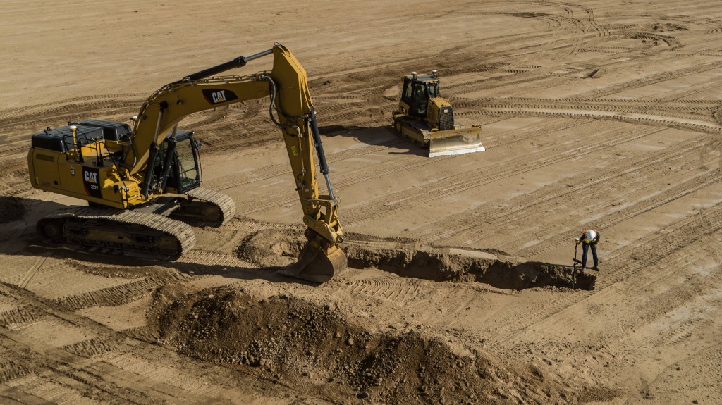 A Cat excavator and dozer are parked on a dirt-filled job site