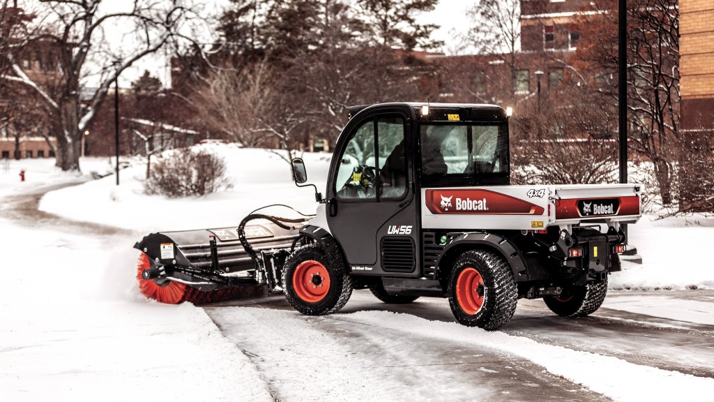 A utility work machine brushes away snow on a road