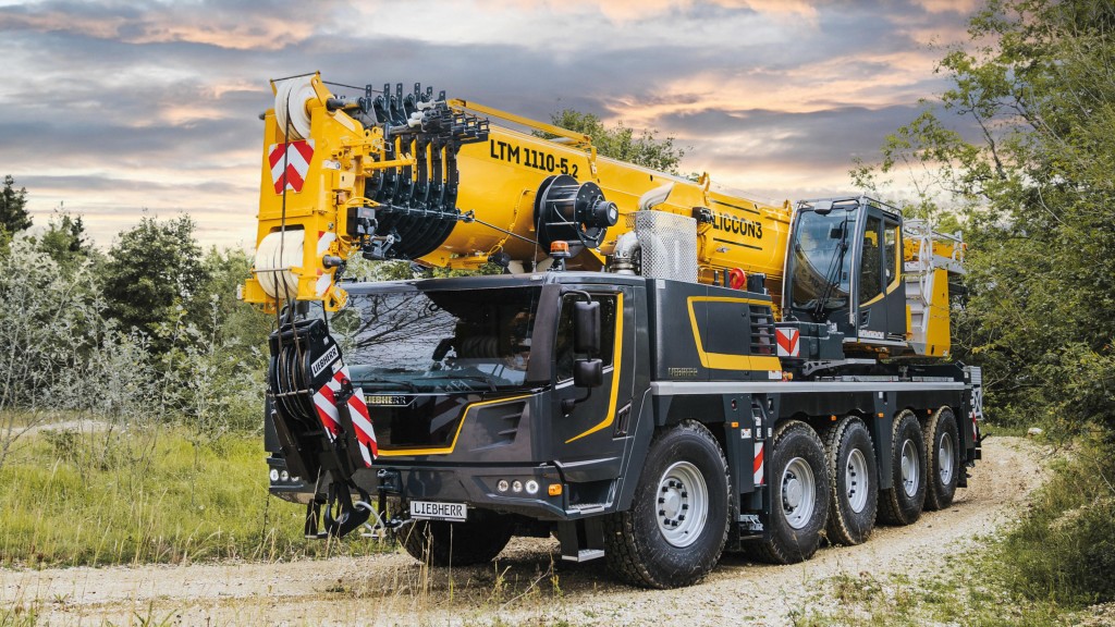 A mobile crane travelling on a dirt road