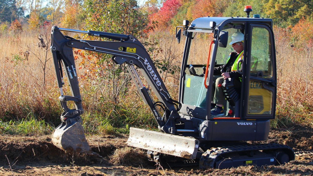 An electric mini excavator digs on a nature refuge
