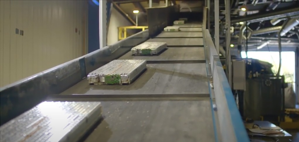 EV batteries on a conveyor belt heading to shredder