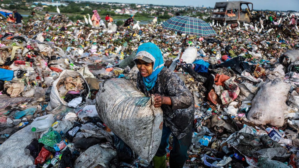 Old woman working in waste pile in Indonesia