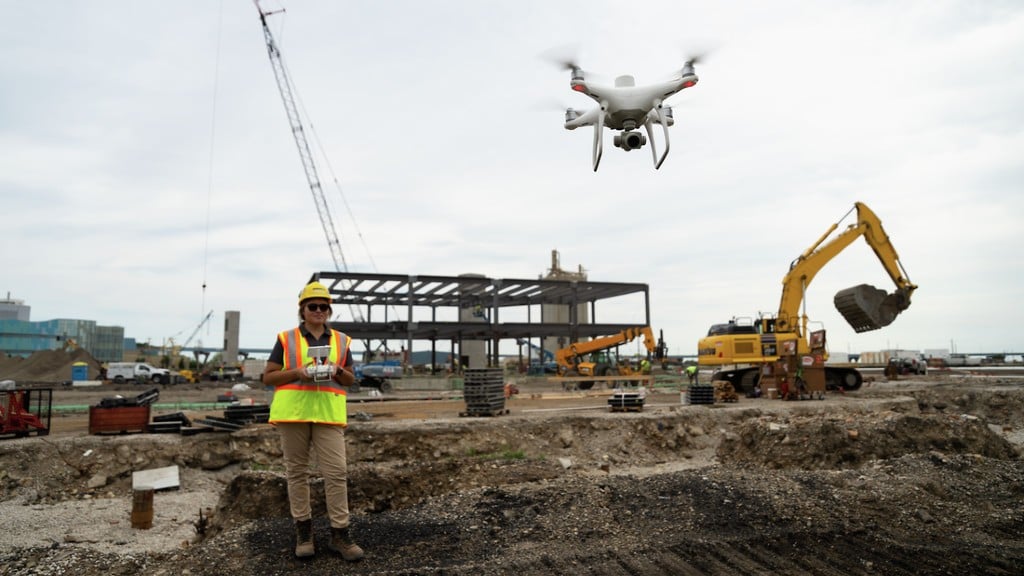 An operator controls a drone on a job site