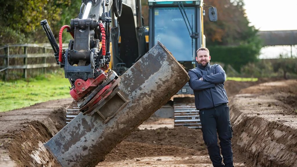 Eoin O'Connor leans against an excavator bucket