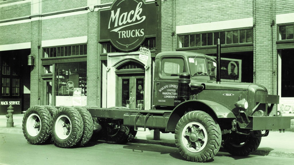 A Mack LR parked on the side of a 1940's street