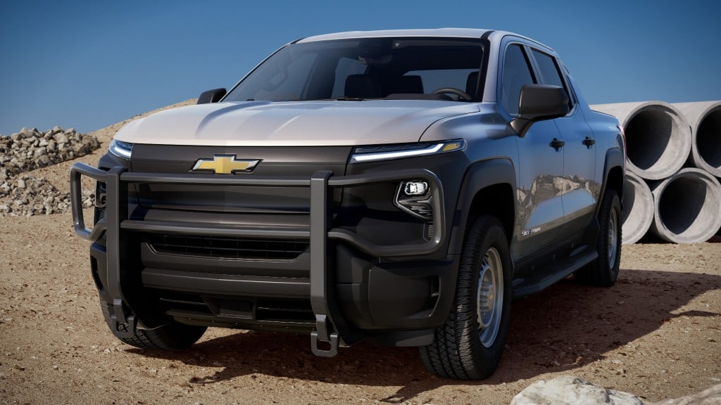 A Chevrolet Silverado EV in front of concrete pipes on a job site