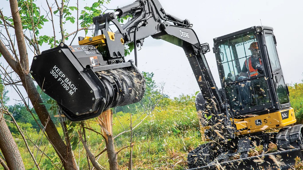 A mulcher mulches down a tree on the job site