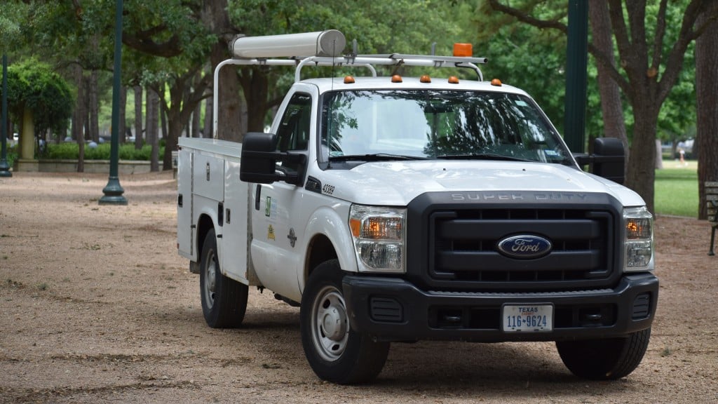 A Ford utility truck is parked in a city park