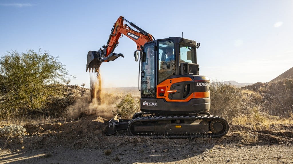 A mini excavator moves dirt on the job site