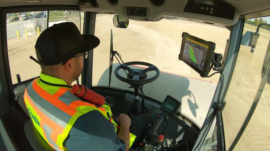 An operator with touchscreen inside a soil compactor cab
