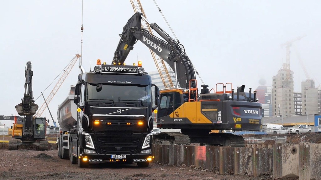 An excavator loads material into a truck