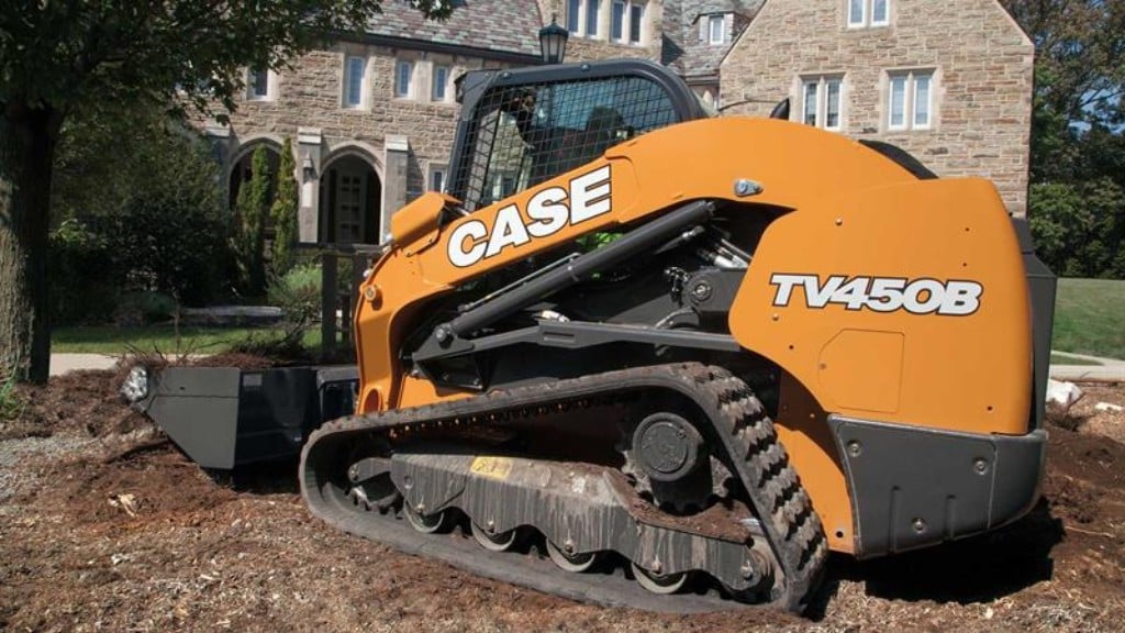 A compact track loader moves dirt on a landscaping job site