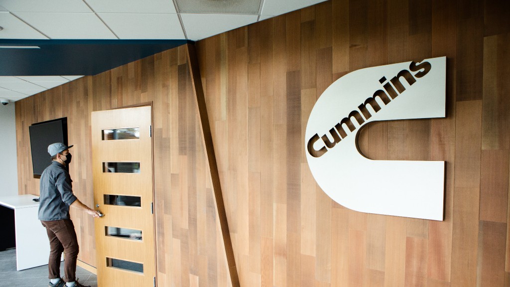 A person walks through a door in a wall with a Cummins logo