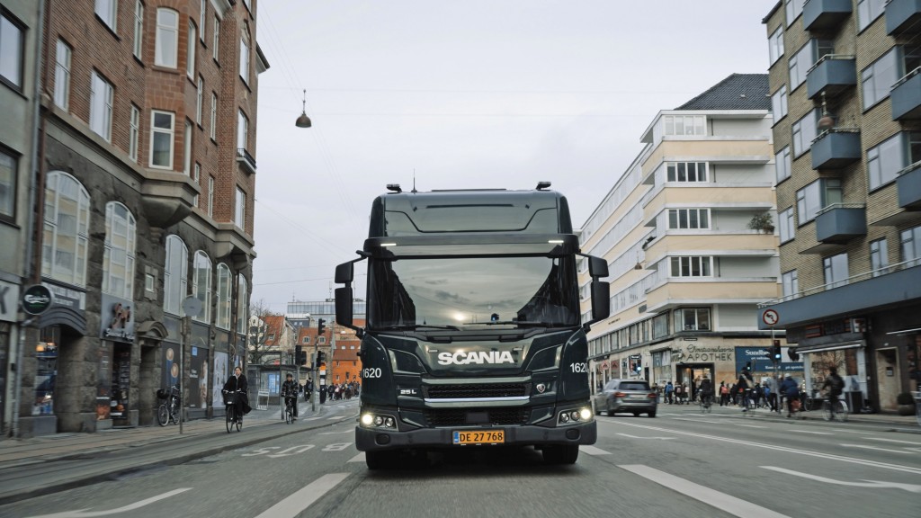 A Scania electric truck driving on a city road