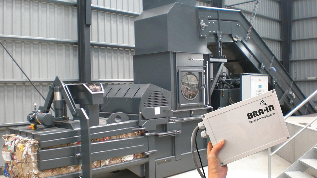 A baler squishes cardboard into a bale