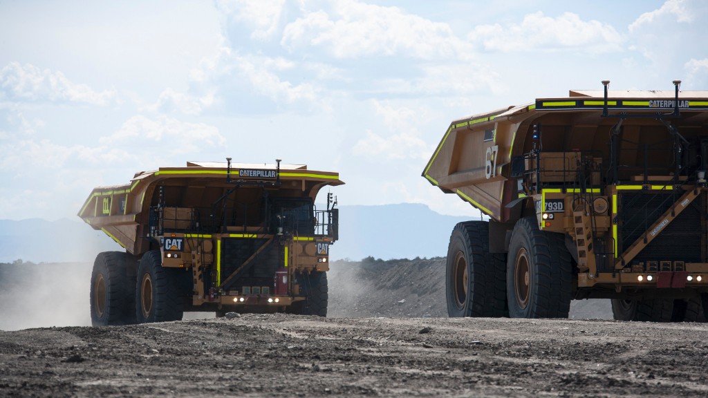 Cat mining trucks drive on a job site
