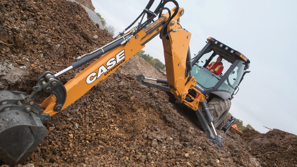 A backhoe loader digs dirt on the job site