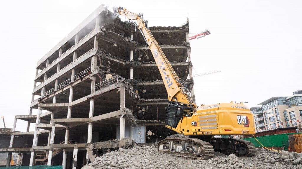 A demolition excavator demolishes a building