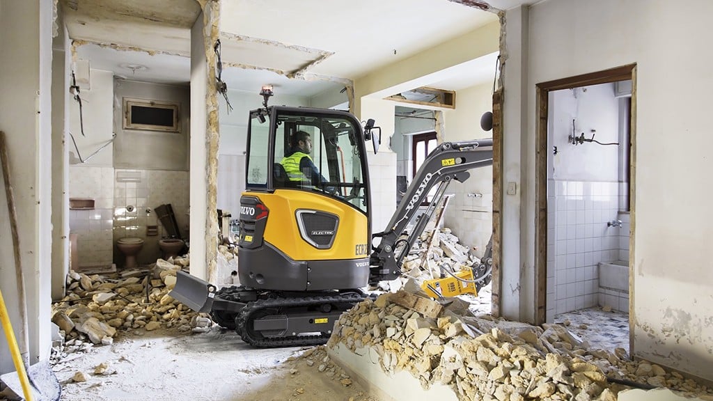 An excavator working on a demolition project inside a building