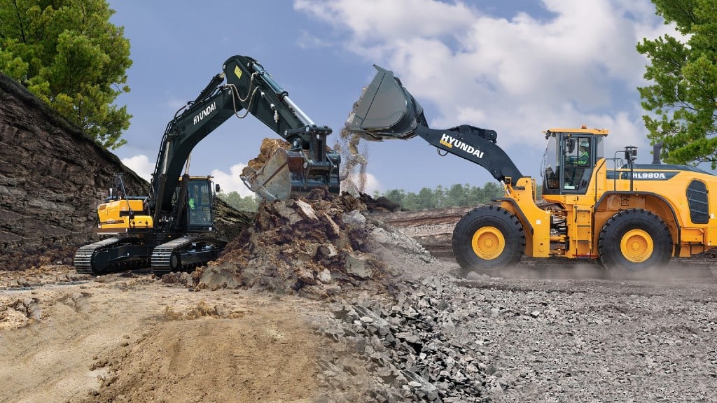 An excavator and wheel loader move material on a job site